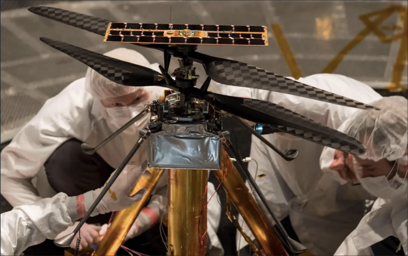  Представители программы Mars Helicopter осматривают летную модель (реальный аппарат, который отправился на Красную планету) в вакуумной камере диаметром 7,62 м в Лаборатории реактивного движения NASA в Пасадене, 1 февраля 2019 года. Фото NASA 